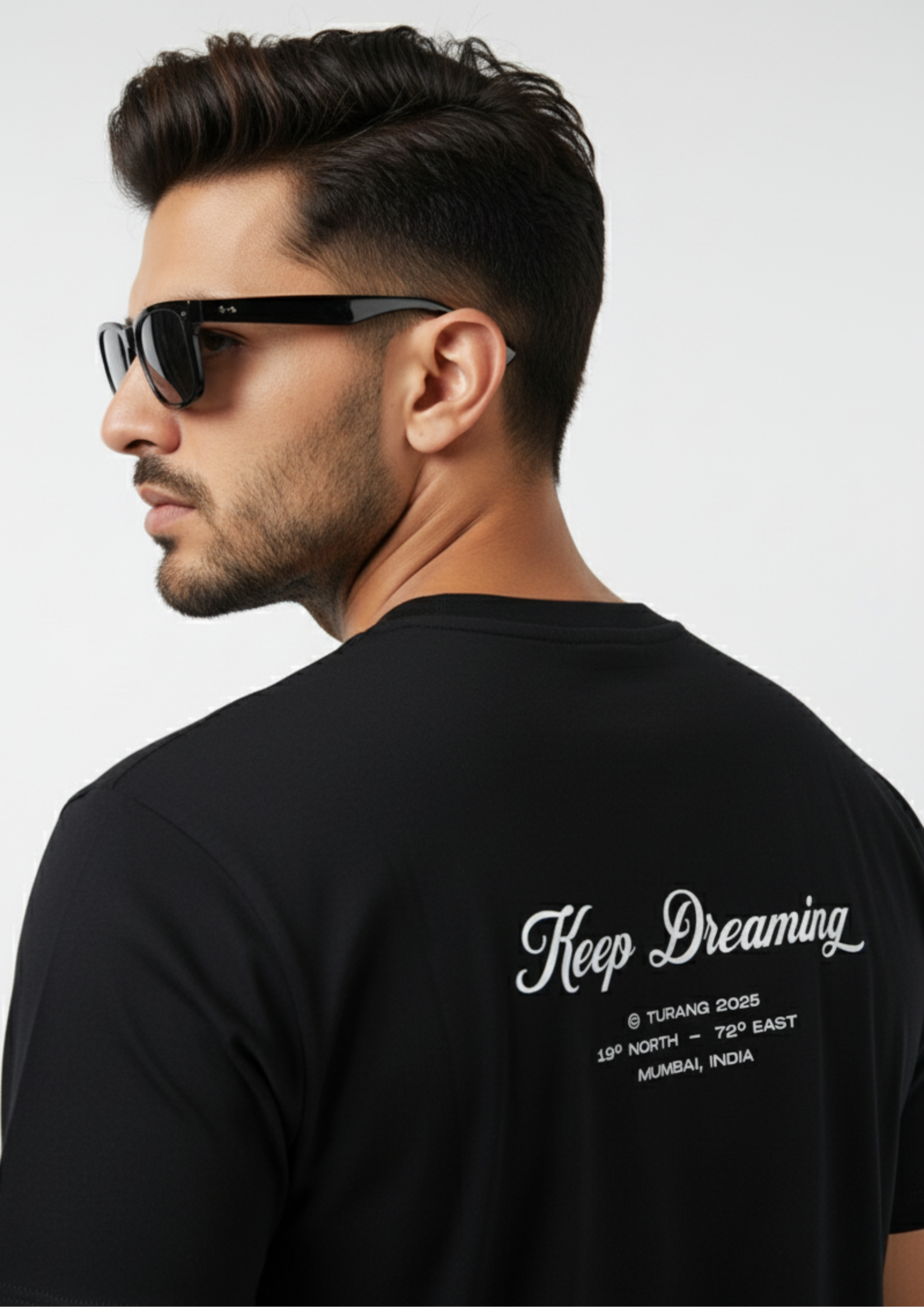 Man wearing a black t-shirt with text on the back, against a plain background