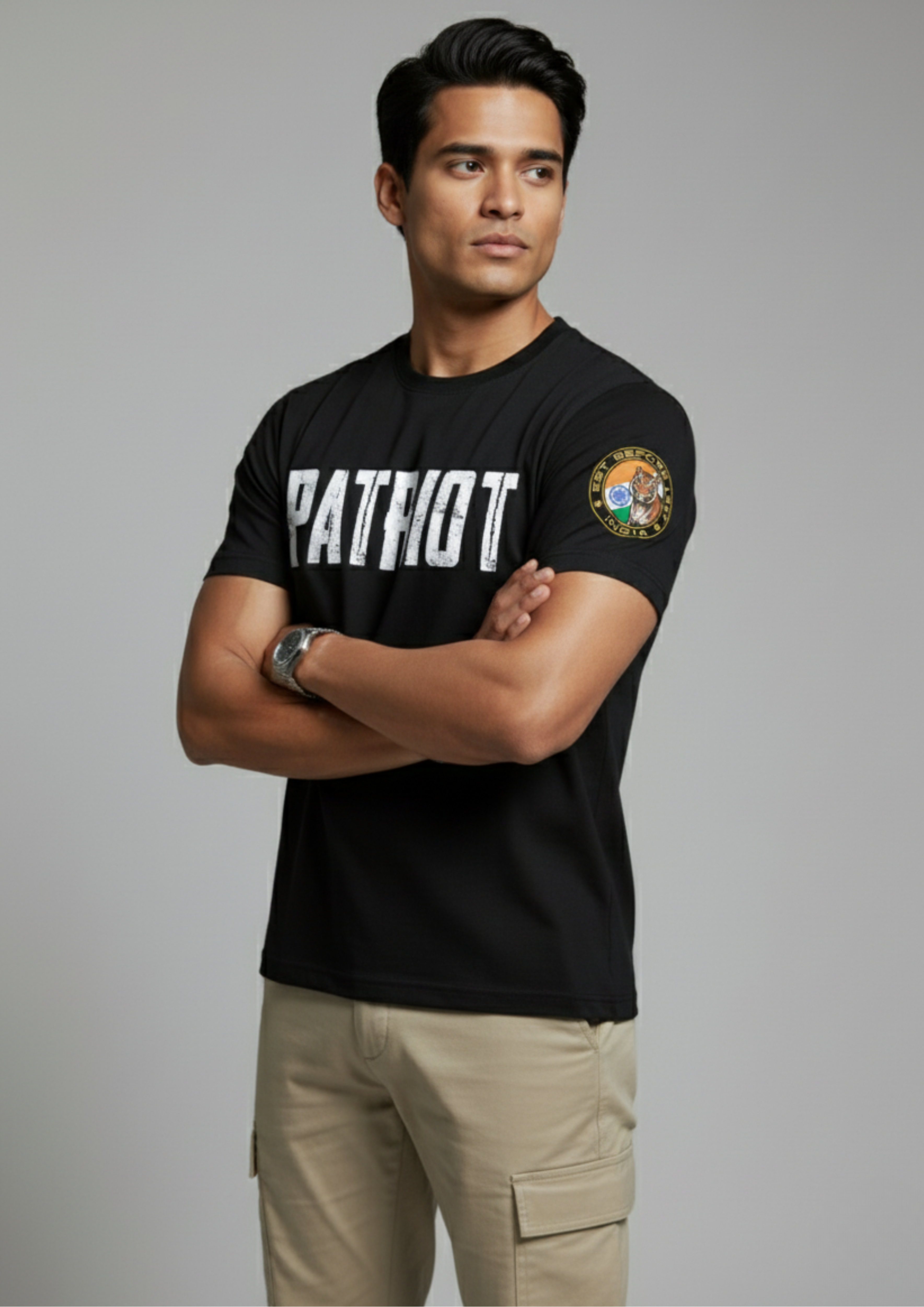 Man wearing a black t-shirt with 'Patriot' text and a patch, standing against a gray background